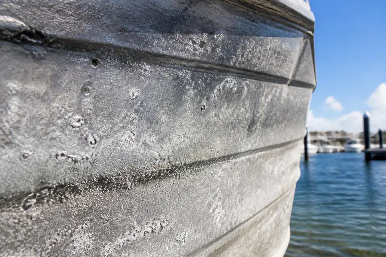 Pitting corrosion sur une coque en aluminium, signe que l'aluminium rouille dans des environnements marins.