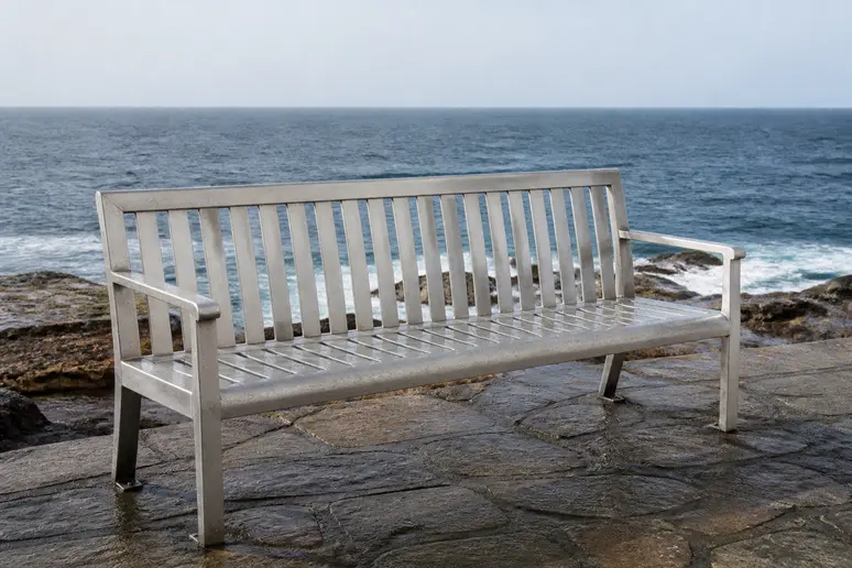 Mobilier de jardin en aluminium sur le littoral, surface ternie suggérant une corrosion là où l'aluminium rouille.