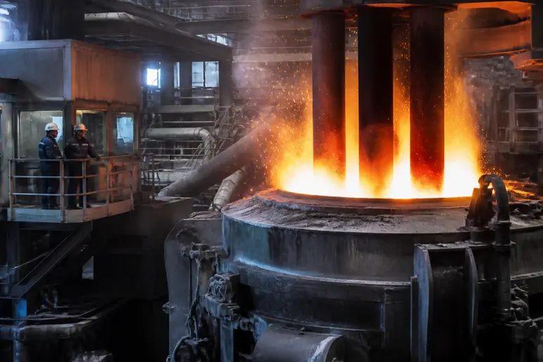 Four à arc électrique en fonctionnement dans une usine de recyclage de ferrailles d'acier.