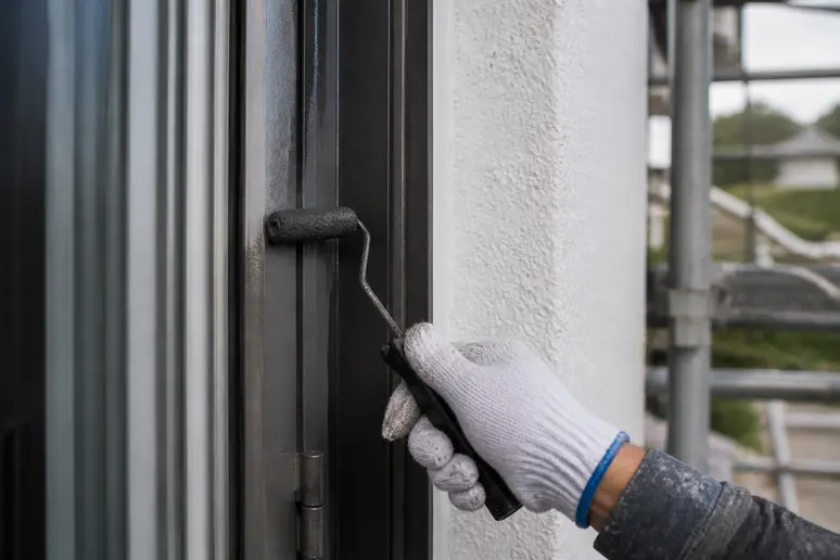Application au rouleau de la peinture sur une menuiserie en aluminium
