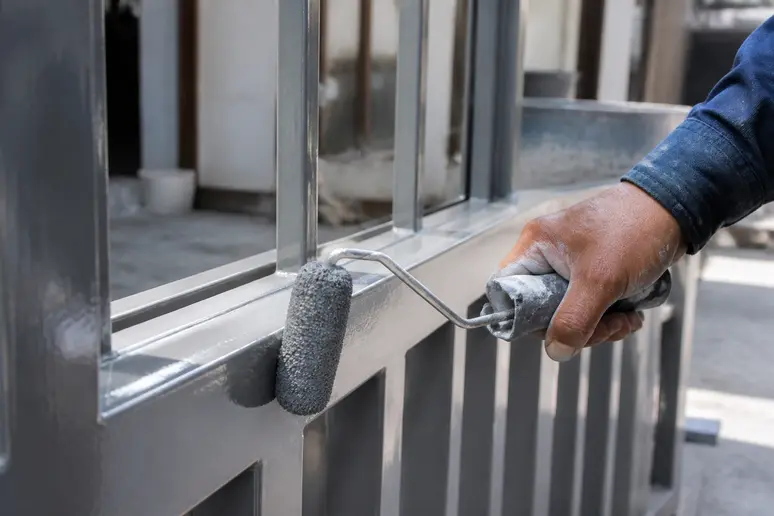 Application manuelle de peinture époxy pour métal au rouleau sur une surface en atelier