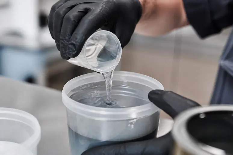 Mélange d'une peinture époxy pour métal et de son durcisseur dans un seau de préparation